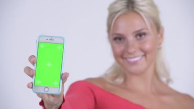Mutlu genç güzel sarışın kadın gösteren telefon yüzü