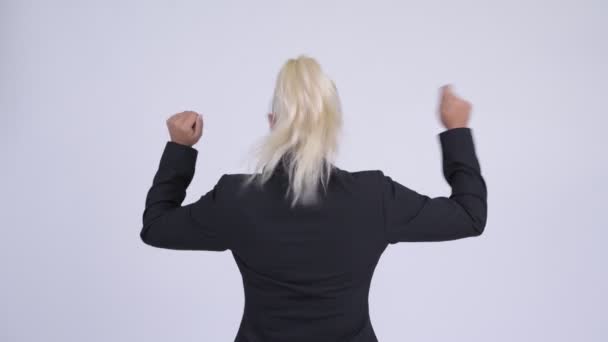 Vue arrière de jeune femme d'affaires blonde heureuse avec les poings levés — Video