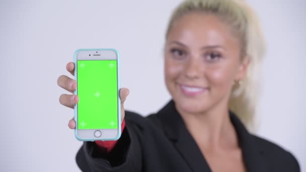 Face of young happy blonde businesswoman showing phone — Stock Video