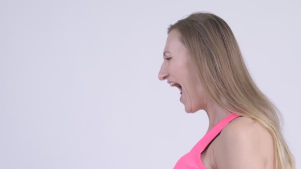 Closeup profile view of angry blonde woman shouting and screaming — Stock Video