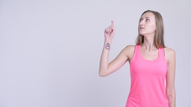 Porträtt av glada blond kvinna tänka och pekar uppåt — Stockvideo