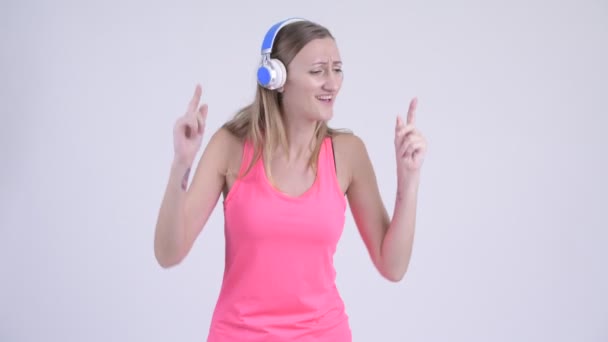 Retrato de mujer rubia feliz escuchando música y bailando — Vídeos de Stock