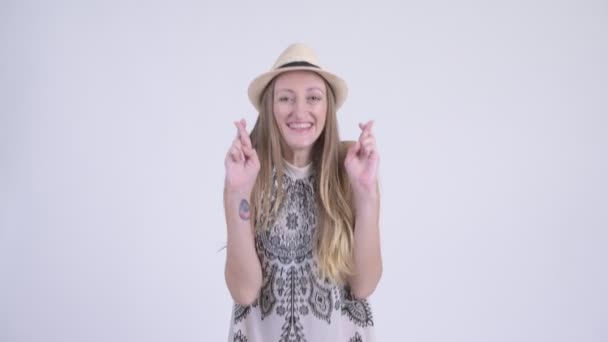 Portrait of happy blonde tourist woman wishing with fingers crossed — Stock Video