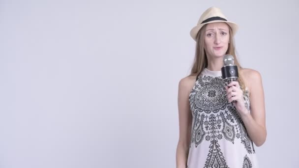 Glückliche blonde Touristin benutzt Mikrofon und präsentiert etwas — Stockvideo