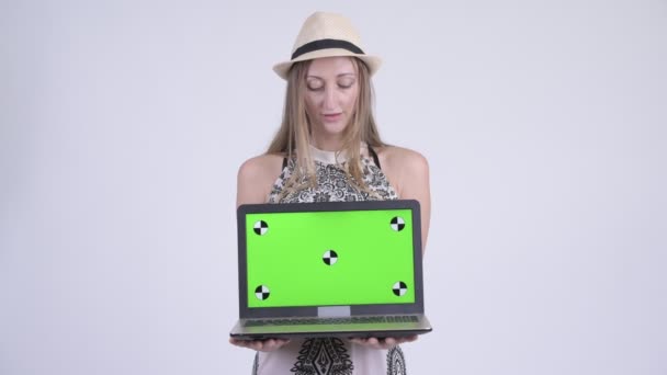 Porträtt av glada blond turist kvinna tänker samtidigt visar laptop — Stockvideo