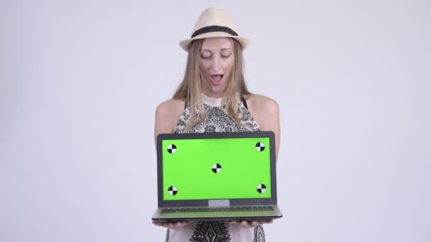 Dizüstü bilgisayarı gösteren ve sürpriz arıyor mutlu sarışın turist kadın — Stok video