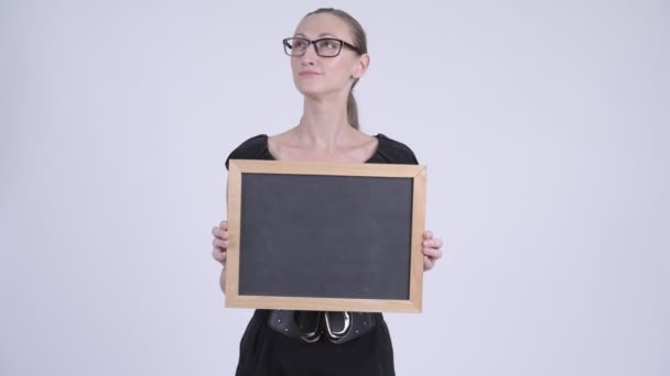 Porträtt av glada blond affärskvinna tänkande medan du håller blackboard — Stockvideo