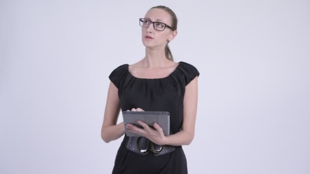 Heureuse femme d'affaires blonde penser tout en utilisant une tablette numérique — Video