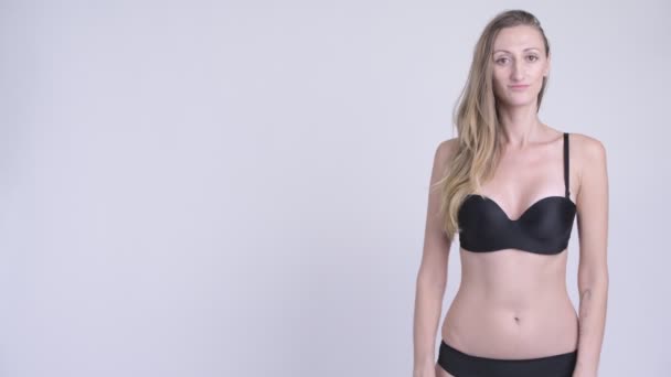 Retrato de mujer rubia feliz en bikini mostrando algo — Vídeos de Stock