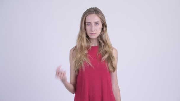 Молодая серьезная блондинка, указывающая на камеру — стоковое видео