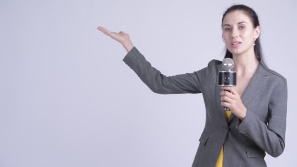 Gelukkige jonge mooie zakenvrouw als nieuwslezer presenteren iets — Stockvideo
