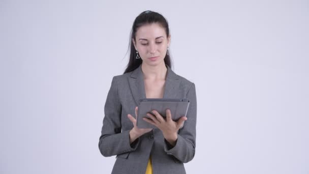Счастливая молодая красивая деловая женщина думает, используя цифровой планшет — стоковое видео