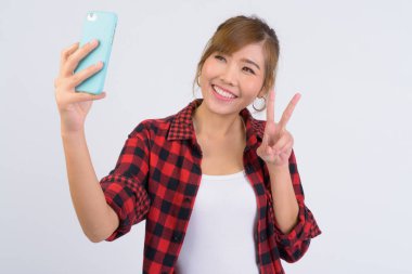 Selfie barış işareti ile alarak genç mutlu Asya hipster kadın portresi