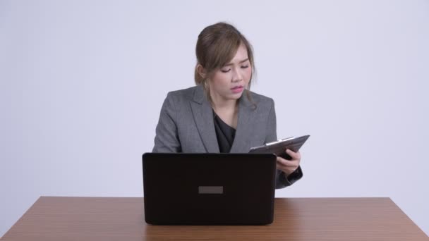 Junge gestresste asiatische Geschäftsfrau Multitasking bei der Arbeit — Stockvideo