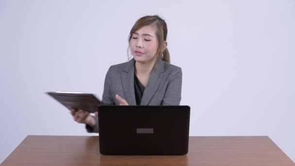 Unga glada asiatiska affärskvinna multitasking på jobbet — Stockvideo