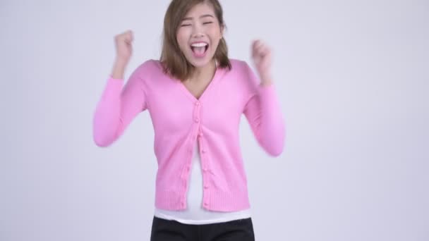 親指をあきらめながら興奮して見て若い幸せなアジア女 — ストック動画