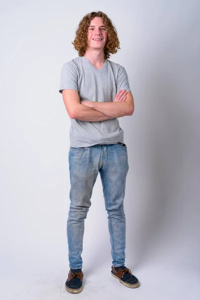 Bote de cuerpo entero de joven y guapo hombre feliz sonriendo con los brazos cruzados — Foto de Stock