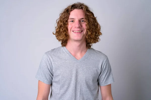 Rosto de jovem e bonito homem feliz com cabelo encaracolado sorrindo — Fotografia de Stock