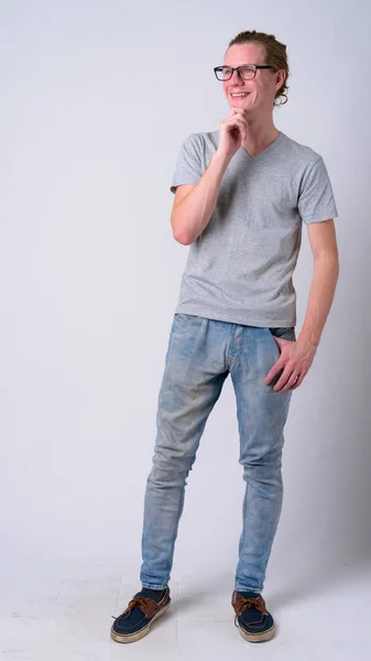 Full body shot of young happy man with eyeglasses thinking — Stock Photo, Image