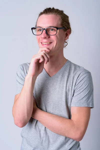 Retrato de hombre joven y guapo feliz con anteojos pensando —  Fotos de Stock