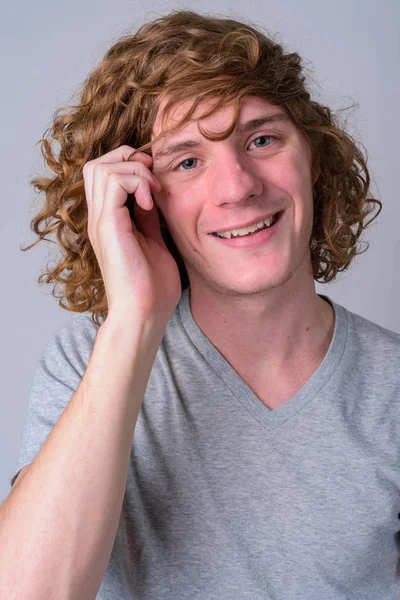 Cara de hombre joven y guapo feliz con el pelo rizado sonriendo — Foto de Stock