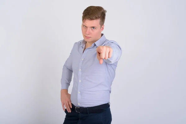 Porträt eines jungen wütenden blonden Geschäftsmannes, der auf die Kamera zeigt — Stockfoto