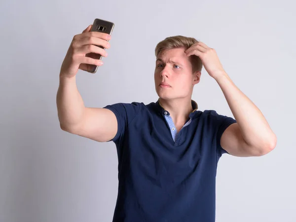 Portret młodej blond przystojny mężczyzna biorąc selfie — Zdjęcie stockowe