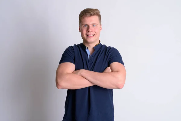 Retrato de joven hombre guapo feliz sonriendo con los brazos cruzados — Foto de Stock