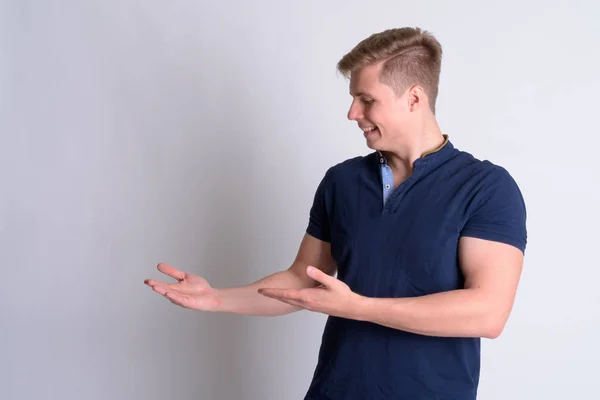 Retrato de jovem feliz bonito homem mostrando algo — Fotografia de Stock