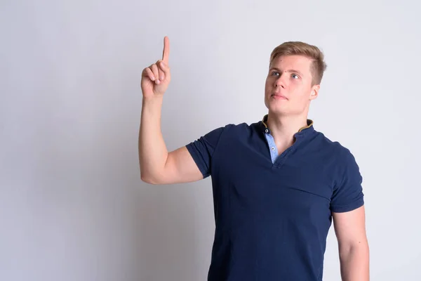 Retrato de jovem loira bonito homem pensando e apontando para cima — Fotografia de Stock