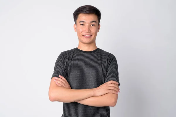 Retrato de joven feliz hombre asiático sonriendo con los brazos cruzados —  Fotos de Stock