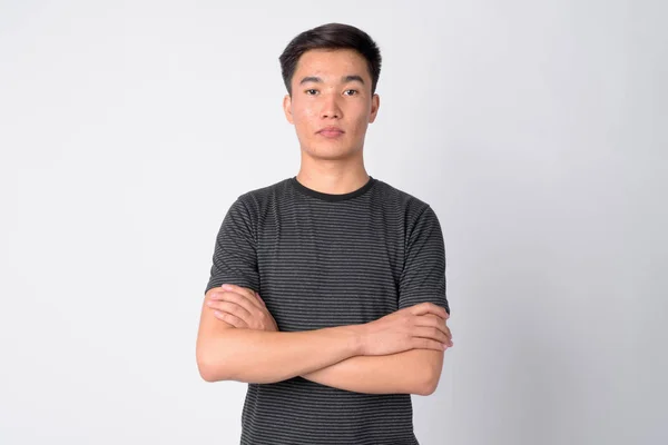 Porträtt av ung vacker asiatisk man med armarna korsade — Stockfoto