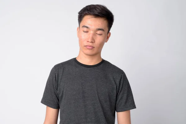 Ansikte av ung vacker asiatisk man avkopplande med slutna ögon — Stockfoto