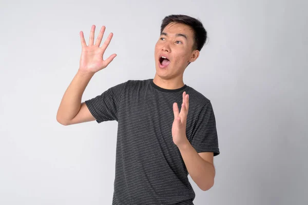 Porträt eines jungen verängstigten asiatischen Mannes, der schockiert wirkt — Stockfoto