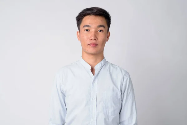 Лицо молодого привлекательного азиатского бизнесмена, смотрящего в камеру — стоковое фото