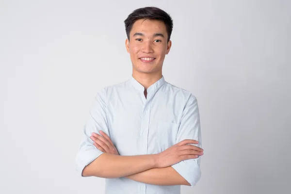 Retrato de joven feliz empresario asiático sonriendo con los brazos cruzados — Foto de Stock