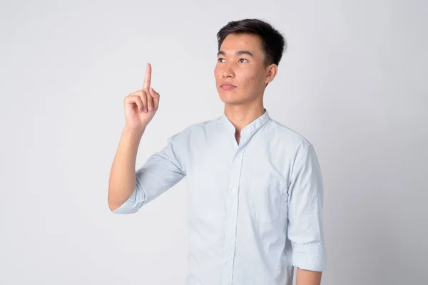 Ritratto di giovane bell'uomo d'affari asiatico che pensa e indica — Foto Stock