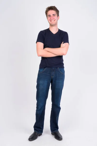 Full body shot of happy young handsome man smiling with arms crossed — Stock Photo, Image