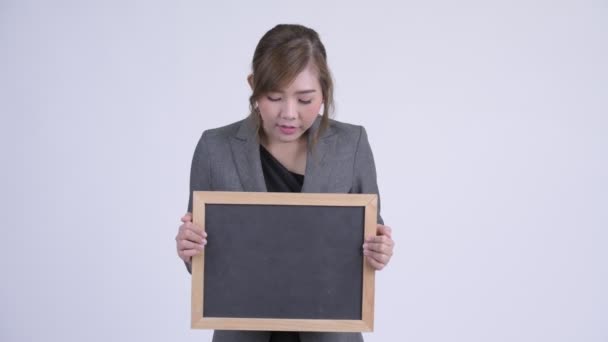 Unga glada asiatiska affärskvinna holding blackboard — Stockvideo