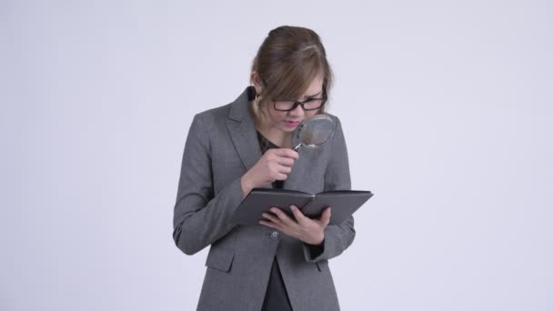 Joven mujer de negocios asiática leyendo libro con lupa — Vídeos de Stock