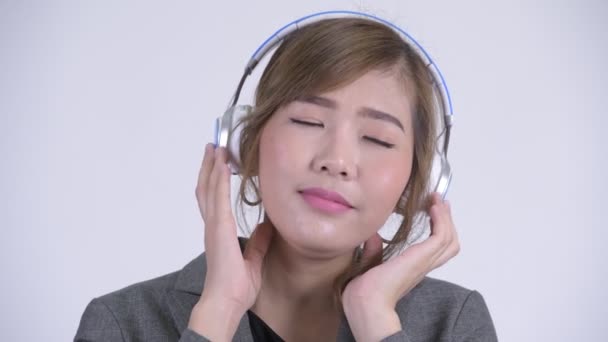 Rostro de joven feliz empresaria asiática escuchando música con los ojos cerrados — Vídeo de stock