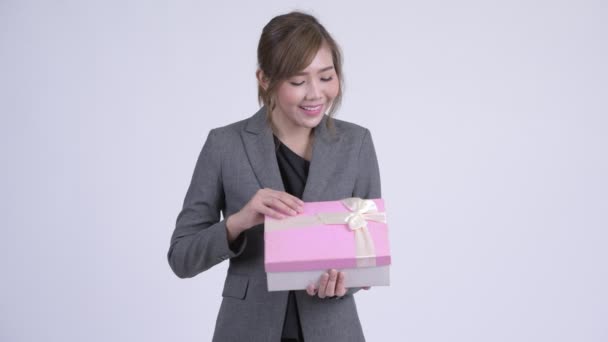 Jovem mulher de negócios asiática feliz abrindo caixa de presente e olhando surpreso — Vídeo de Stock