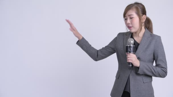 Boldog fiatal ázsiai üzletasszony, mint bemondó bemutató valami — Stock videók