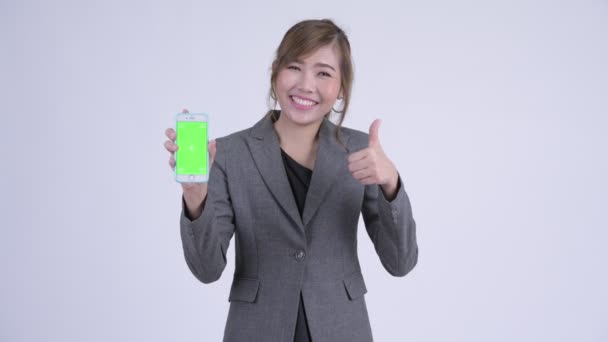 Молодий щасливі азіатських бізнес-леді показ телефонів і даючи великі пальці — стокове відео