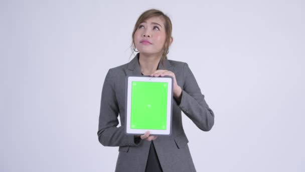 Jeune femme d'affaires asiatique heureux penser tout en montrant tablette numérique — Video