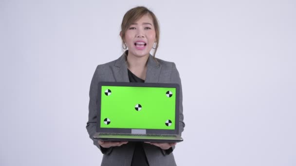 年轻快乐的亚洲女商人一边展示笔记本电脑一边说话 — 图库视频影像