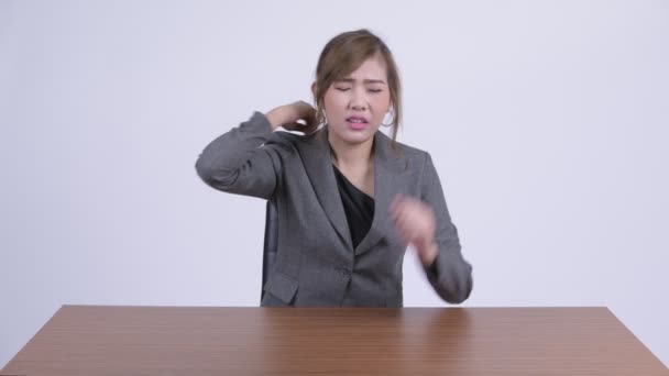 Junge gestresste asiatische Geschäftsfrau mit Nackenschmerzen am Schreibtisch — Stockvideo