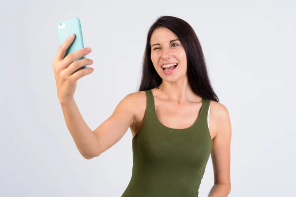 Portrait of happy young beautiful woman winking and taking selfie — Stock Photo, Image