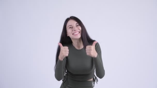 Glückliche junge schöne Frau schaut aufgeregt, während sie die Daumen nach oben gibt — Stockvideo