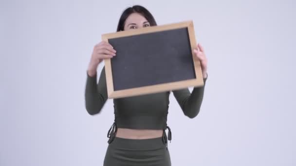 Jovem feliz bela mulher mostrando quadro-negro como surpresa — Vídeo de Stock